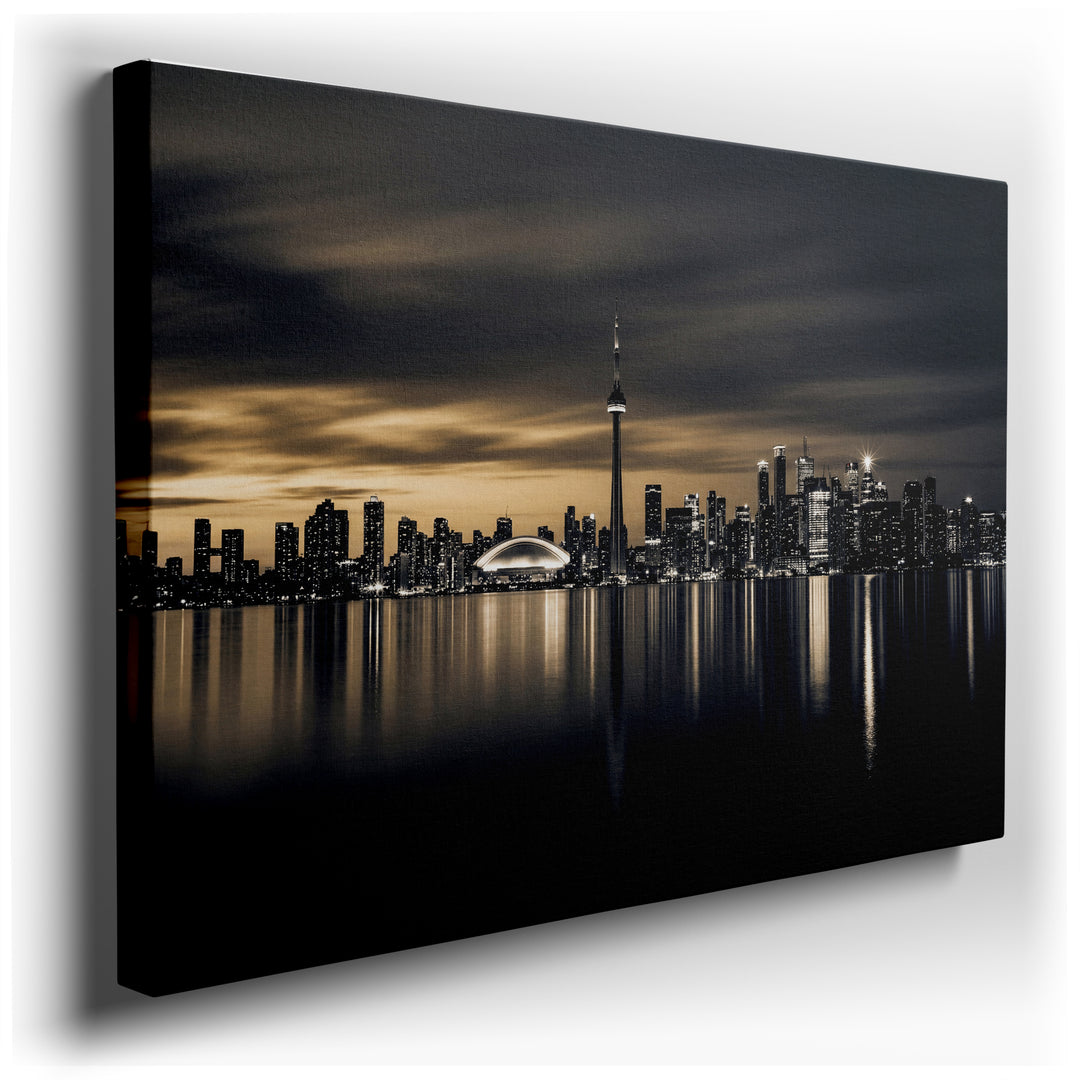Canvas print showing the iconic Toronto cityscape at night, featuring the CN Tower and skyscrapers reflected in Lake Ontario. Monochromatic art with subtle gold accents.