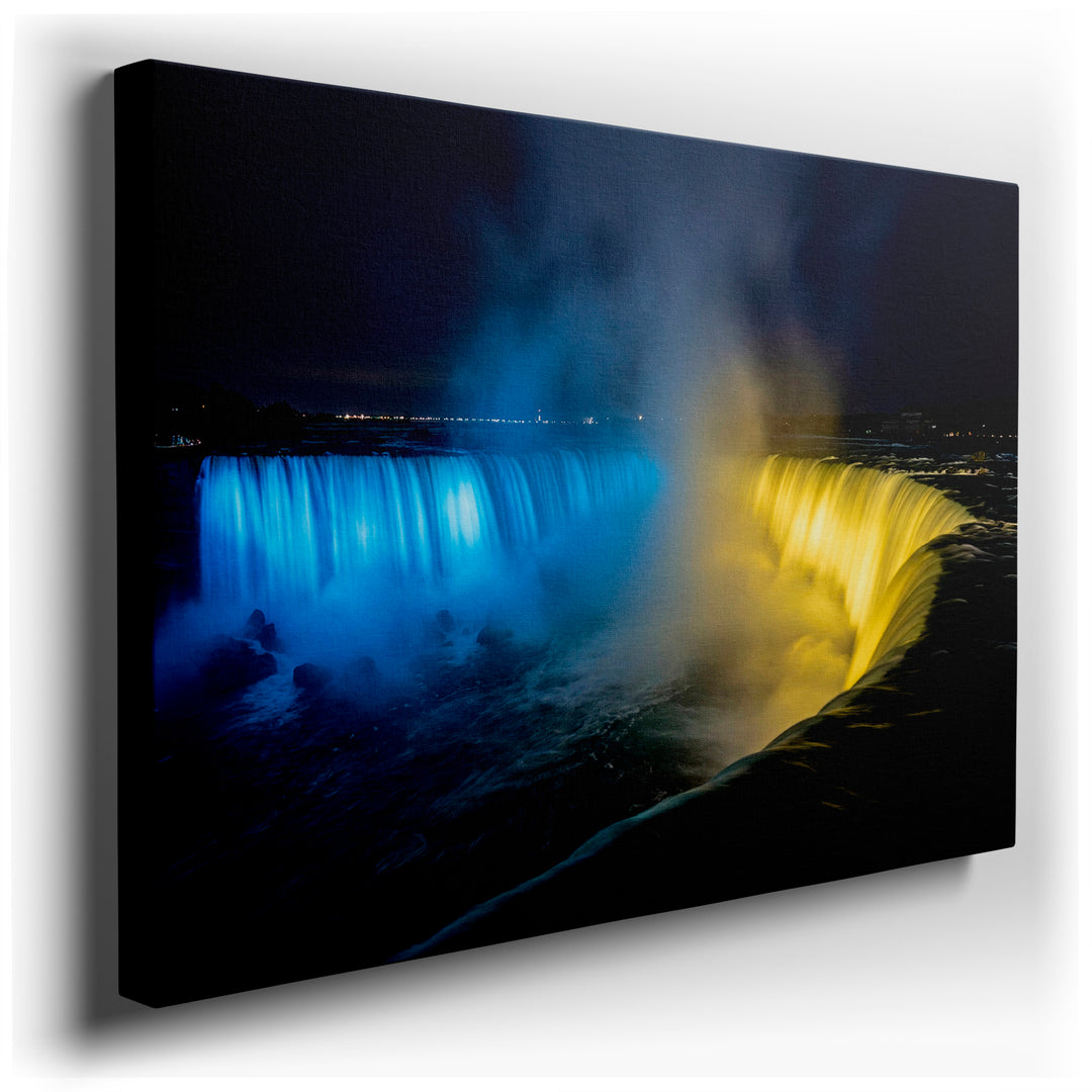 Niagara Falls wall art illuminated at night with vibrant blue and yellow lights creating a dynamic, scenic display.