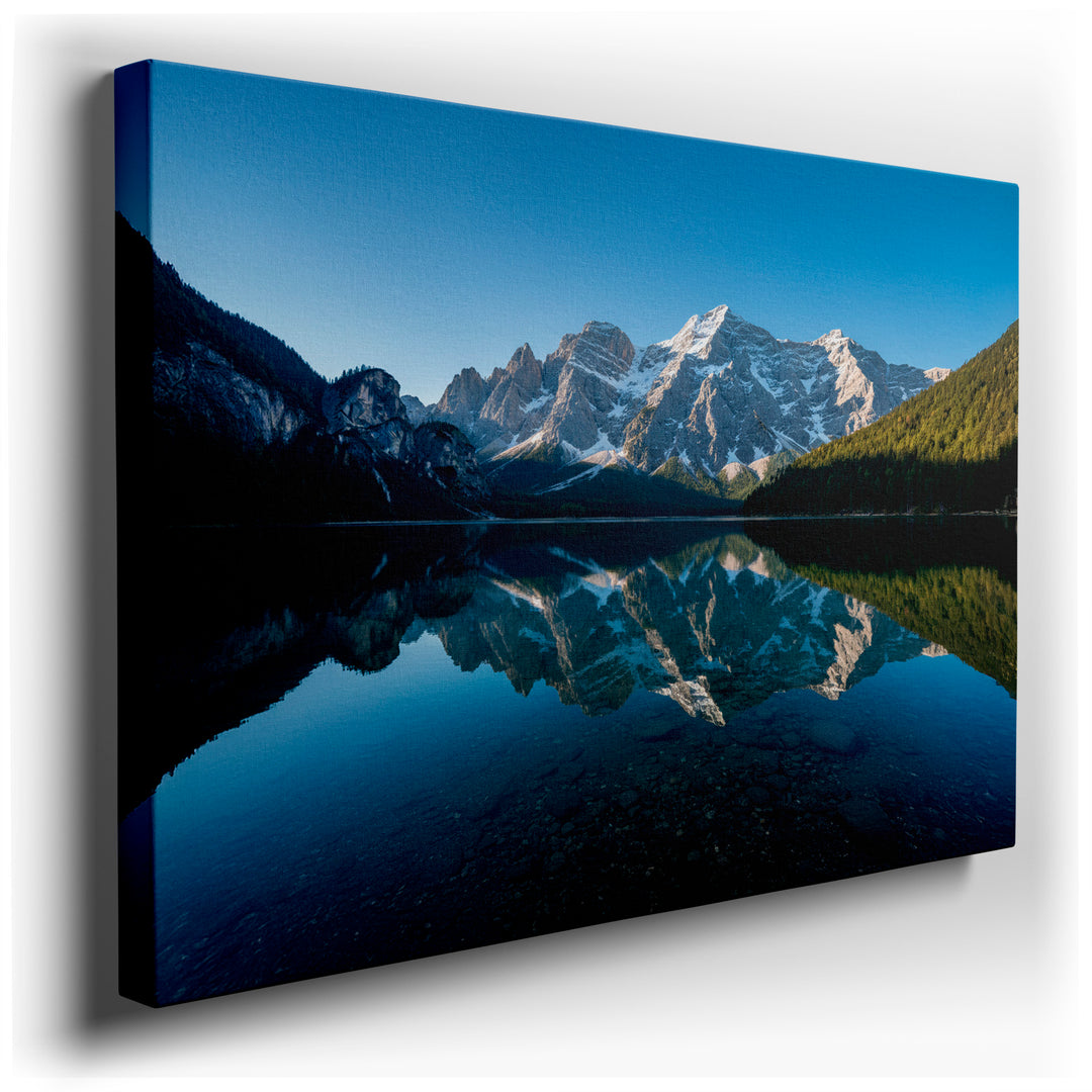 Tranquil mountain lake wall art reflecting snow-capped peaks and forest in clear water, creating a serene nature scene.