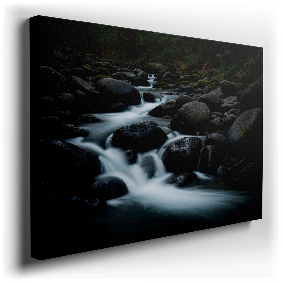 A tranquil river cascades over smooth, dark stones; a calming wall art piece for nature-inspired interiors.