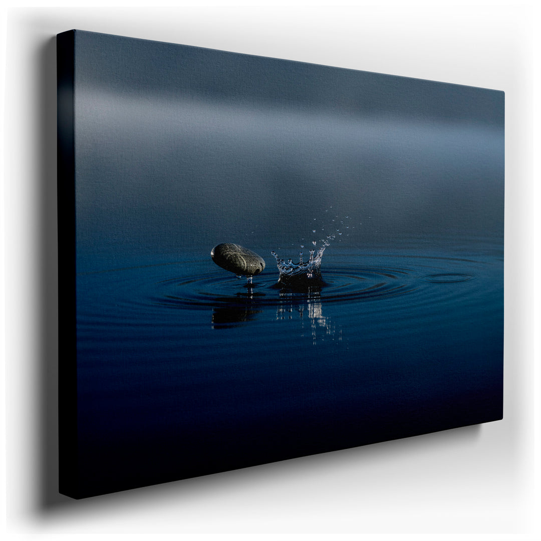 A tranquil scene of a stone creating a water splash, forming delicate ripples in a calming blue water, serene wall art.