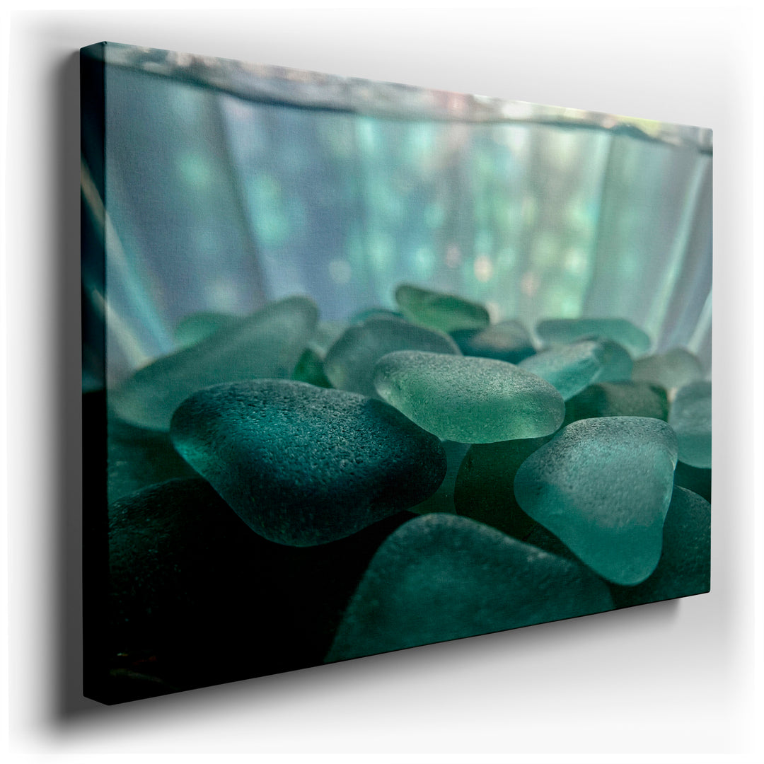 Close-up wall art of sea glass in varying blue hues, creating a textured and calming visual. Coastal home decor.