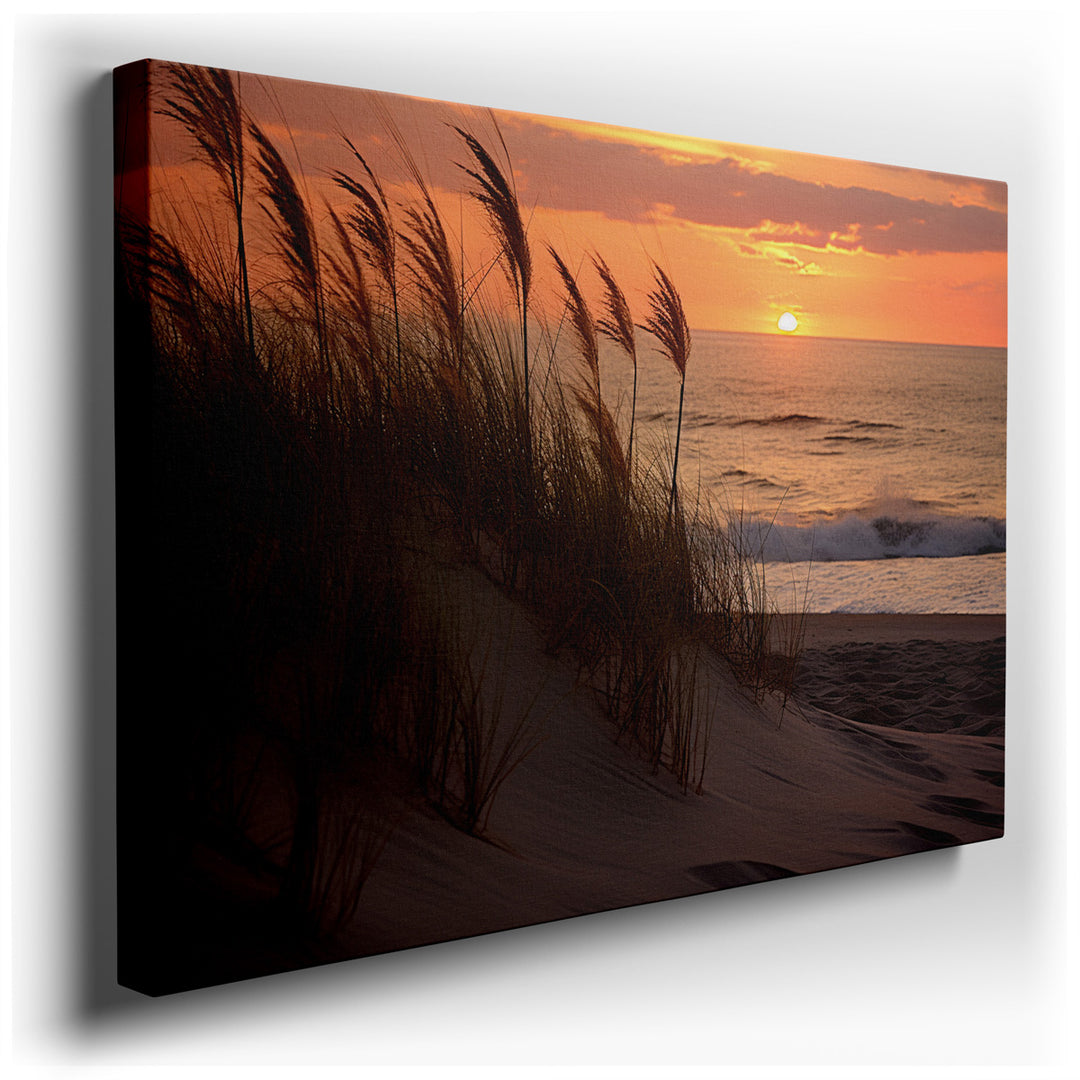 canvas print on wrapped canvas for wall decor – This wall art captures a serene moment at sunset, where golden strands of grass delicately crown the crest of a sandy du...
