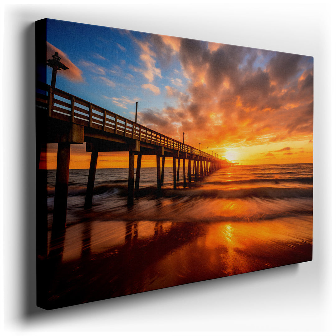 canvas print on wrapped canvas for wall decor – This wall art captures an energetic sunset view of an ocean pier, masterfully portraying the interplay of light on the u...