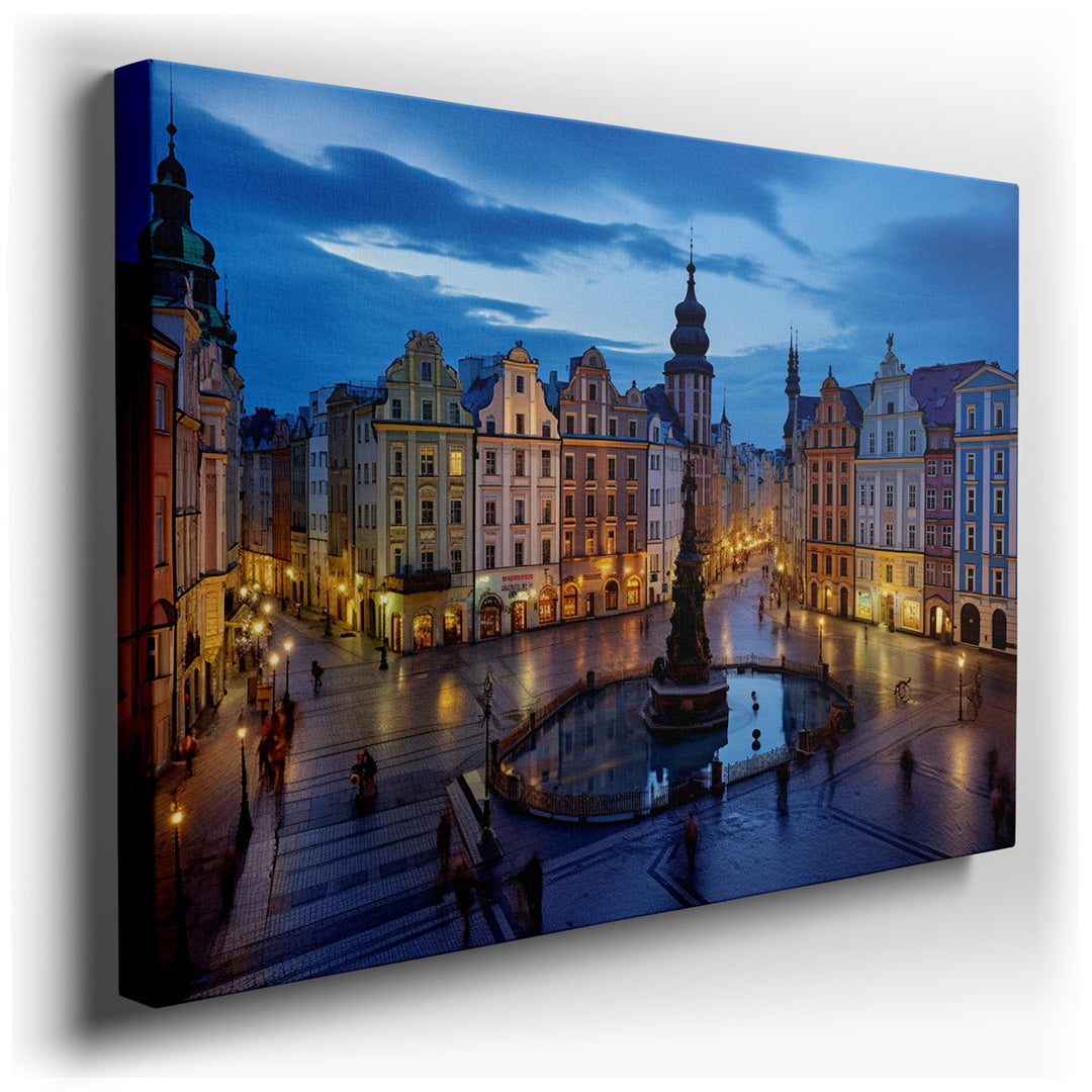 canvas print on wrapped canvas for wall decor – This wall art masterfully captures an enchanting urban scene at dusk, set in a bustling city square that pulses with the...