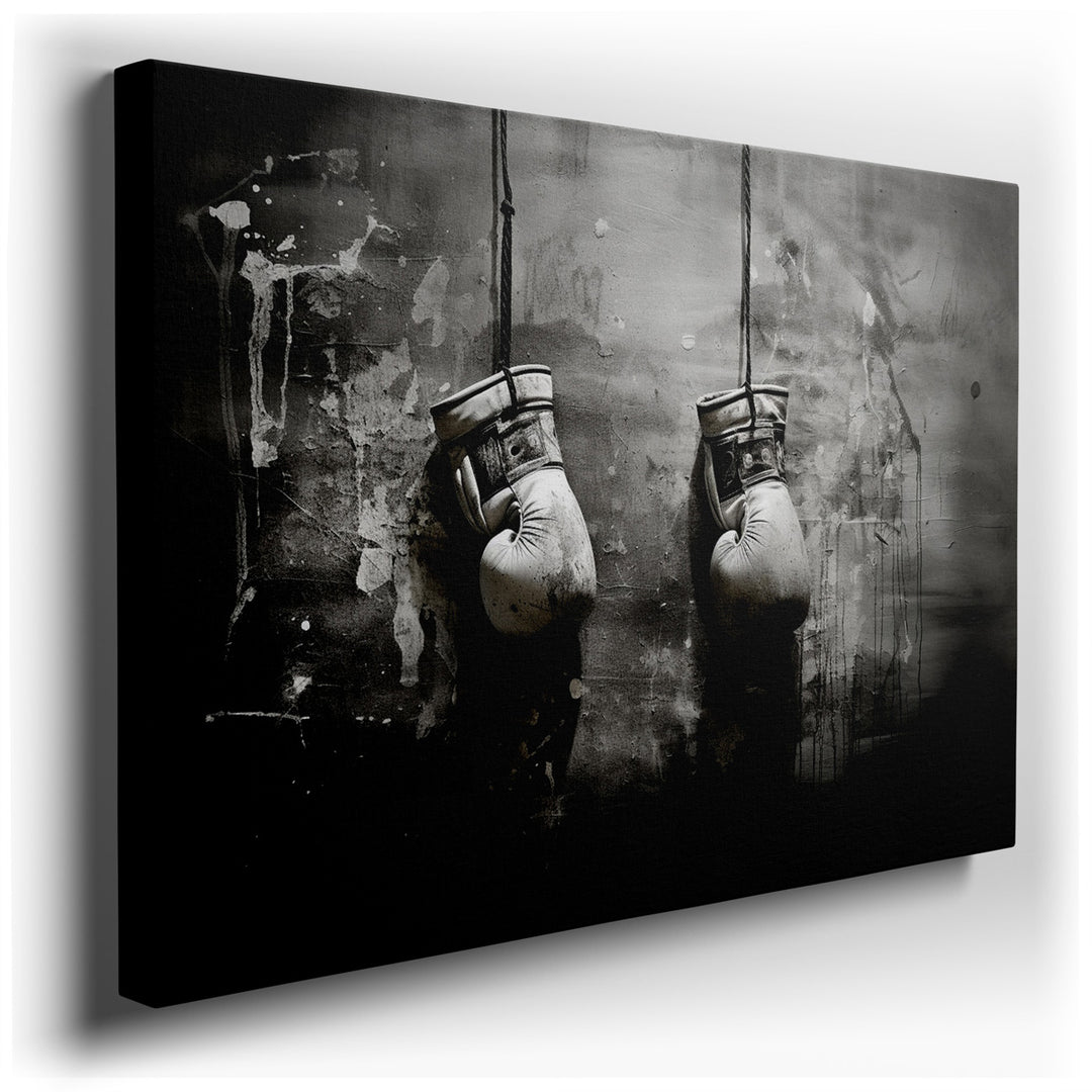 canvas print on wrapped canvas for wall decor – This wall art captures a poignant and evocative image, rendered in stark black and white, of a pair of worn boxing glove...